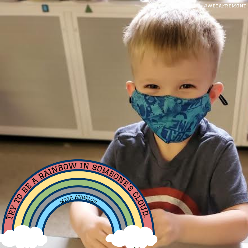 Young male student wearing mask with a rainbow quote that says, "Try to be a rainbow in someone's cloud." Maya Angelou