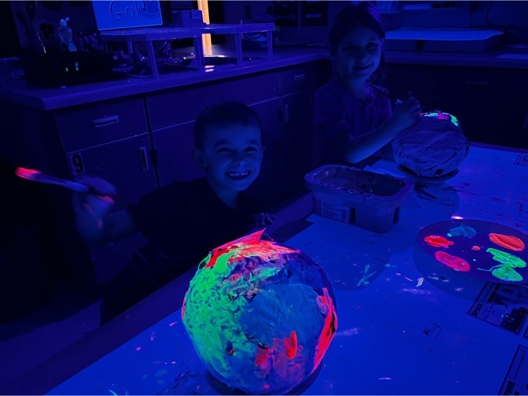 students posing with their paper mache planets 